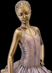 Elegant ballerinafigur i bronze-finish stående på trælignende base, håndmalet og stilfuld